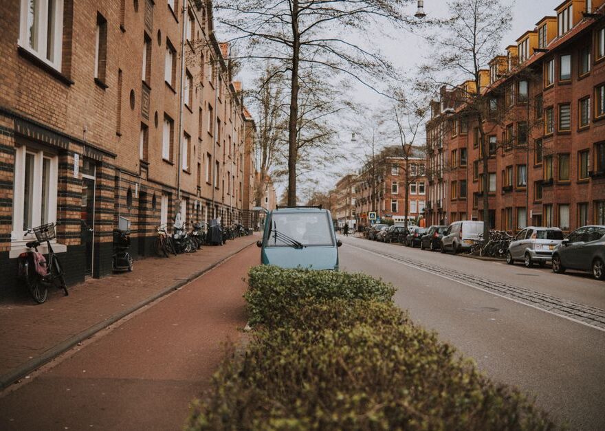 Een rijbewijsvrije brommobiel op een rustige straat, ideaal voor senioren en mensen met een beperking die mobiel willen blijven.